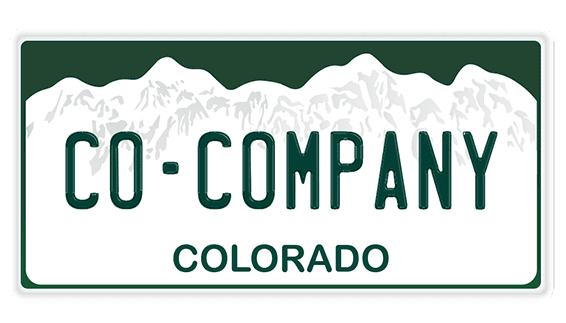 A green and white license plate with mountains in the background.